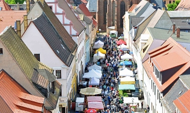 Das Foto zeigt die Breite Straße mit Ständen beim Frühlings- und Genuss-Markt in Delitzsch im Mai 2024.